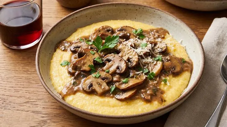 Polenta con salsa de hongos y queso rallado al plato